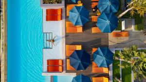 uma vista superior para uma piscina com cadeiras e guarda-sóis em Bandara Phuket Beach Resort em Panwa Beach