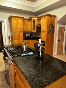 a kitchen with wooden cabinets and a black counter top at Hidden Gem Exuma - KING BED master suite and central air in Georgetown