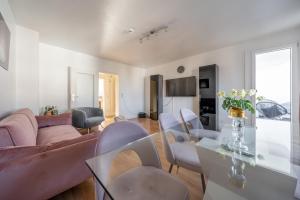 a living room with a pink couch and chairs at Private Apartment in Lehrte