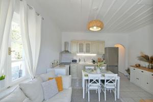 a living room with a white couch and a kitchen at Olivo II Luxury Apartment in Hydra