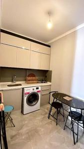 uma cozinha com uma máquina de lavar roupa e uma mesa em Luxury Apartment in the Cordonn Residence City Center em Fethiye