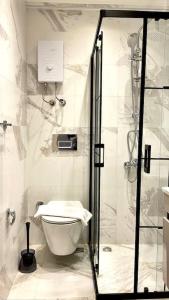 uma casa de banho com um chuveiro e um WC. em Luxury Apartment in the Cordonn Residence City Center em Fethiye