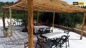 un patio con mesas y sillas bajo una pérgola de madera en Casa rural Bolero-Vadocañas, 