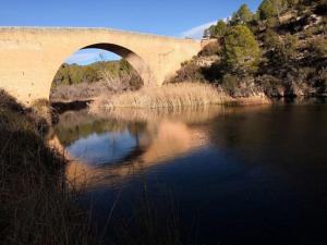 un puente sobre un río con su reflejo en el agua en Casa rural Bolero-Vadocañas, 