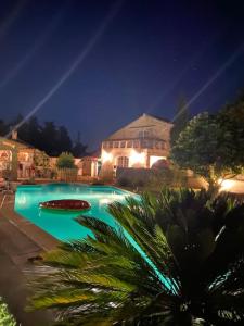 ein Schwimmbad in der Nacht mit einem Haus in der Unterkunft MAS PROVENÇAL AU GRÉ DU HASARD in Cavaillon
