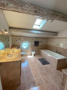 ein Badezimmer mit 2 Waschbecken und einer Badewanne in der Unterkunft MAS PROVENÇAL AU GRÉ DU HASARD in Cavaillon