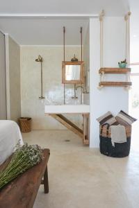 a room with a table and a bench and shelves at Can Tres Formentera in Playa Migjorn