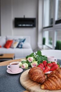 - une table avec des fraises, des croissants et des tasses de café dans l'établissement Keller Apart K12 - Taras z widokiem na wyłączność i klimatyzacją GRATIS, à Porąbka