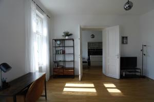 sala de estar con paredes blancas, ventana y estante para libros en Casa Nostra - Moderne lichtdurchflutete Wohnung am Augarten, en Viena