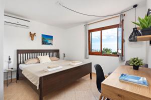 una camera con letto, scrivania e tavolo di Nuriana 4 bedroom villa, Calan Blanes a Cala'n Forcat