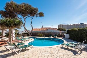 una piscina con sedie a sdraio e un resort di Nuriana 4 bedroom villa, Calan Blanes a Cala'n Forcat