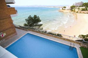 a large blue swimming pool next to a beach at BAHIA II HomeStay by Turismar in Salou