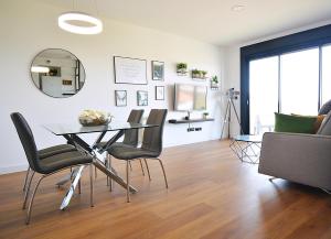 a dining room with a table and chairs at Precioso apartamento con piscina en Sanxenxo in Sanxenxo