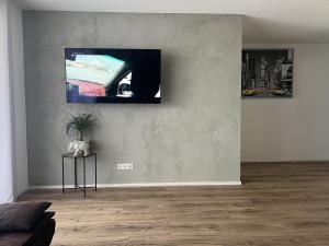 uma sala de estar com uma televisão de ecrã plano na parede em Fewo Dani em Rheinhausen