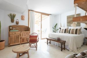 a bedroom with a bed and a table and a chair at Can Tres Formentera in Playa Migjorn