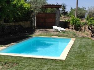 - une piscine bleue dans une cour avec un banc dans l'établissement Cal Martí, à Abella de la Conca