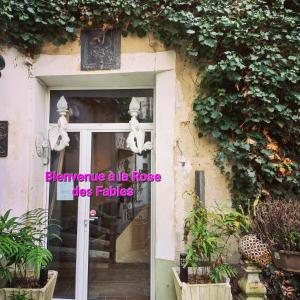 a door to a house with a sign on it at Location meublé de tourisme La Rose des Fables in Château-Thierry