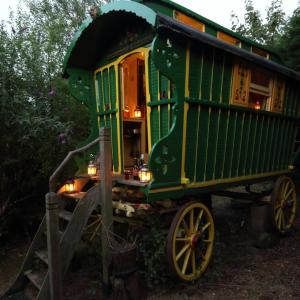 a green train car is sitting on display at Gypsy Caravan at Alde Garden in Saxmundham