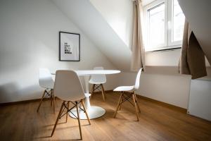 een eetkamer met een tafel en witte stoelen bij Top Old Town Apartment 2 baths in Düsseldorf
