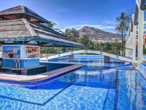 een zwembad in een resort met een prieel bij BenalBeach Playa - Estudio en Benalmadena in Benalmádena