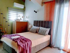 a bedroom with a large bed in a room with windows at Vacations in Patra Studios in Patra