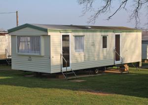 a white tiny house on a trailer in a yard at Cheverton Copse in Sandown