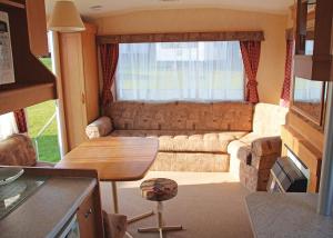 uma sala de estar com um sofá e uma mesa em Cheverton Copse em Sandown