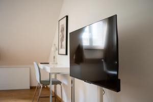 een flatscreen-tv hangend aan een muur naast een tafel bij Top Old Town Apartment 2 baths in Düsseldorf