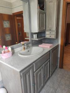 een badkamerbar met een wastafel en een spiegel bij Lara's House in Verona