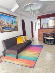 a living room with a couch and a colorful rug at Hospedaje él Familia in Cartagena de Indias