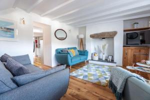 a living room with two blue couches and a table at Beach Lovers Paradise in Portreath - With Sea Views & Log Burner just 100m from beach in Portreath