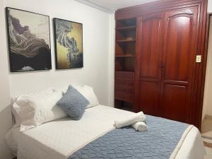 a bedroom with a bed and a wooden cabinet at Hospedaje él Familia in Cartagena de Indias