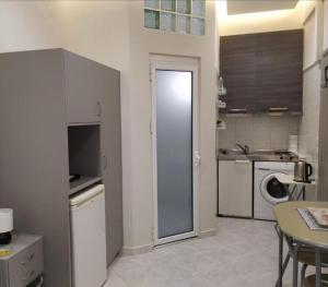 a kitchen with a door open to a kitchen with a washing machine at Vacations in Patra Studios in Patra