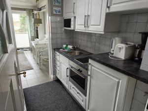a small kitchen with white cabinets and a sink at Berliner Ring - Whg 26 in Wyk auf Föhr