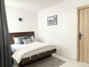 a bedroom with a bed with white walls at Sigma Base Apartments in Lagos