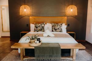 a bedroom with a bed and a wooden table at Linvale Country Lodge in Hazyview