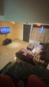 a room with a table and a tv and a couch at Casa Mount View villa wd pvt pool in Lonavala