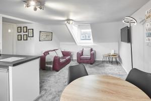 a living room with two chairs and a table at Glencoe Holiday Apartments Whitby in Whitby