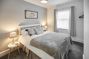 ein Schlafzimmer mit einem großen Bett und einem Fenster in der Unterkunft Glencoe Holiday Apartments Whitby in Whitby