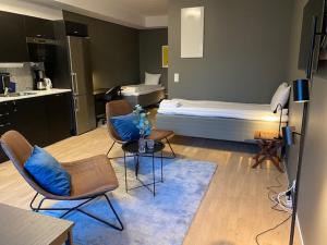a room with a bed and chairs and a kitchen at Magnolia House Norrviken in Sollentuna