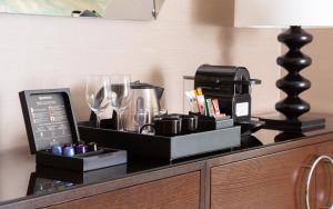 a counter with a coffee maker and glasses on it at JW Marriott Bucharest Grand Hotel in Bucharest