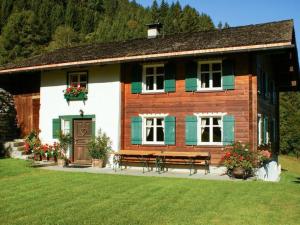 uma casa de madeira com um banco em frente em Ferienhaus Helga em Sankt Gallenkirch