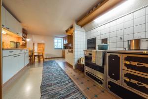 a kitchen with white appliances and a table with a rug at Ferienhaus Helga in Sankt Gallenkirch