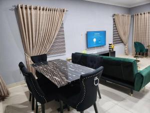 a dining room with a table and chairs and a couch at Spacious Luxury 3Bed Hse in Tema - Netflix Wi-fi in Dawhwenya