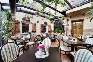 un restaurant avec des tables, des chaises et des plantes dans l'établissement Dark Pub Hotelik, à Gorlice