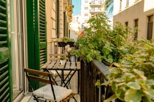 einen Balkon mit einem Stuhl und Pflanzen auf einem Gebäude in der Unterkunft MammaDada charm rooms in Bari