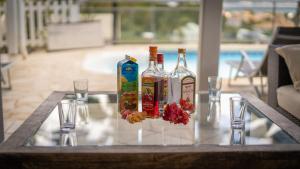 a table with bottles of alcohol and glasses on it at Villa K'Line - Piscine privée, magnifique vue mer aux Trois-Ilets in Les Trois-Îlets