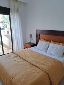 1 dormitorio con 1 cama grande y ventana grande en Roda Golf Penthouse, en San Javier