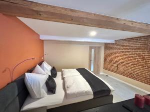 a bedroom with a bed and a brick wall at Chalet im Weindorf Roßbach in Naumburg