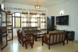 a living room with a table and chairs and a couch at Bujumbura Sweet Home - Maison bien équipée avec voiture gratuite in Bujumbura